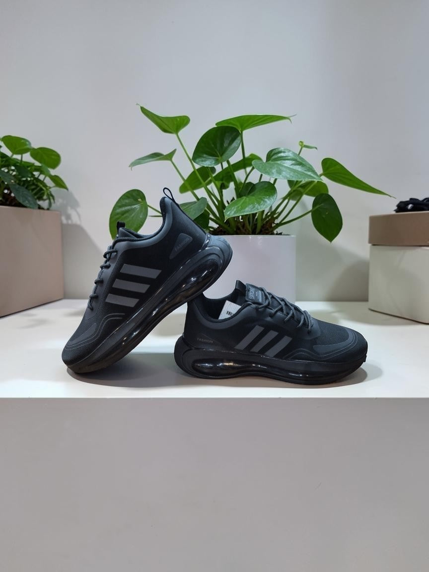PUNK men's black and grey athletic sneakers with cushioned soles and striped side detailing on a white shelf